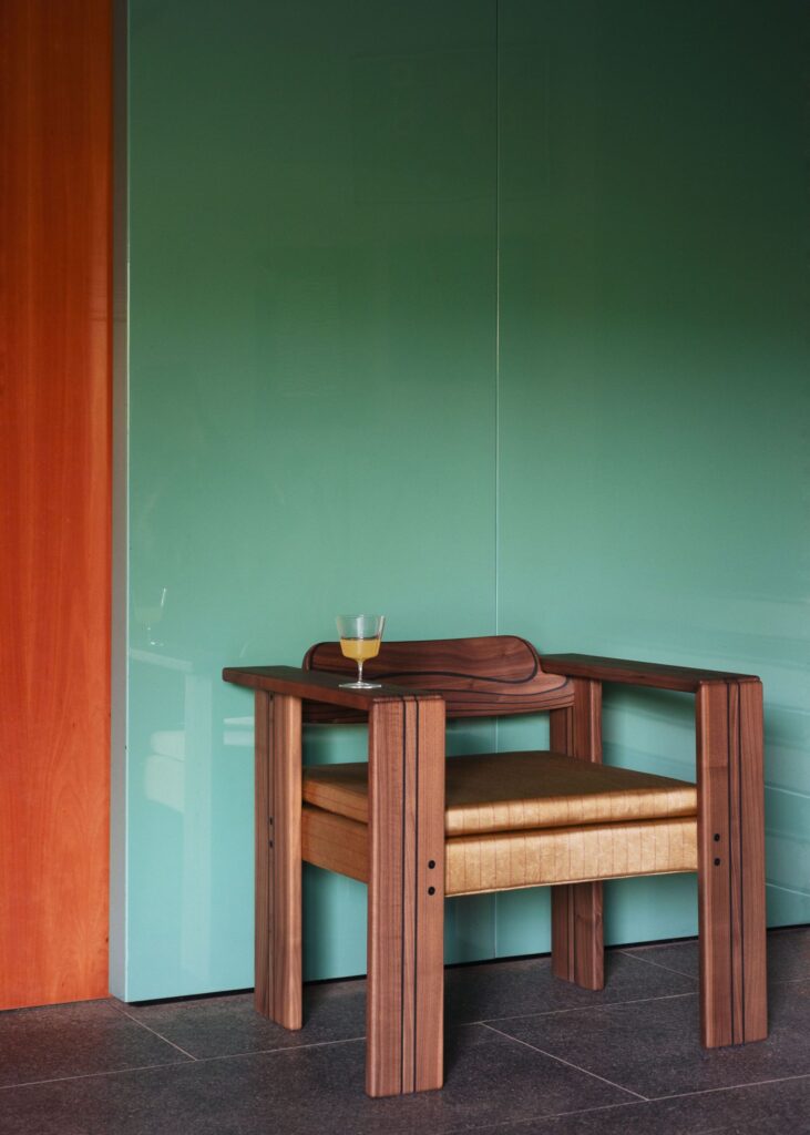 Fauteuil Africa Tacchini en noyer devant un mur laqué vert, projet De Boysson Design